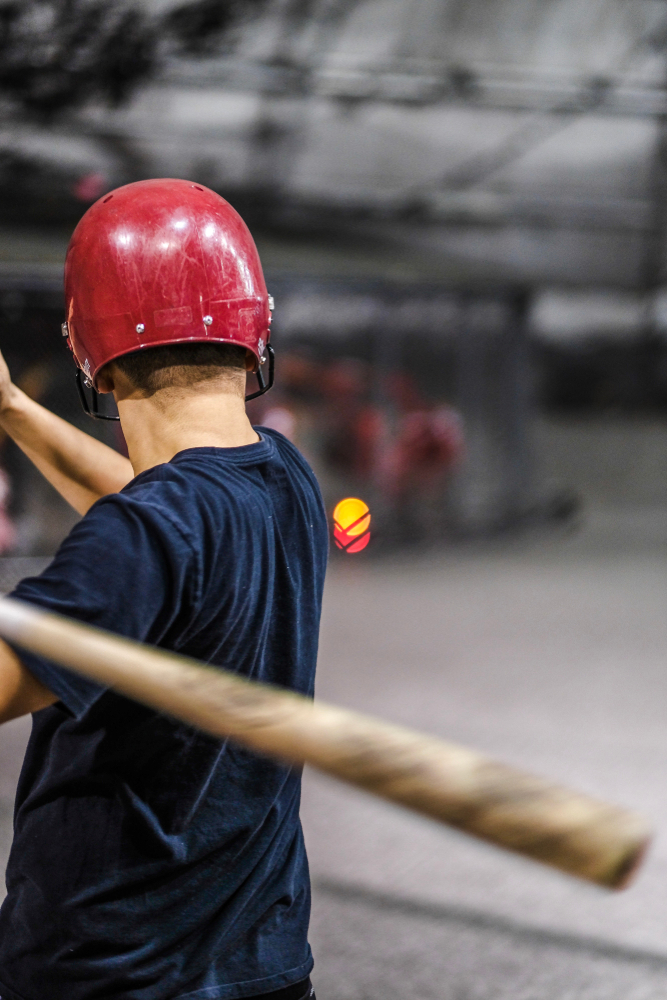 Baseball player hitting in a batting cage